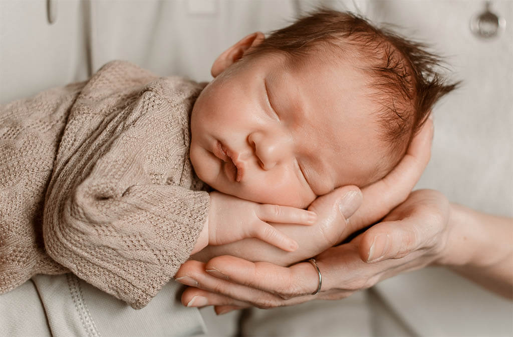 Schlafendes neugeborenes Baby in Salzburg während eines Fotoshootings, liebevoll fotografiert von Monika Nanasi.