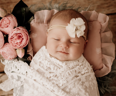 Neugeborenes Baby schläft friedlich eingewickelt in weiche Decke – Neugeborenen-Fotoshooting Salzburg